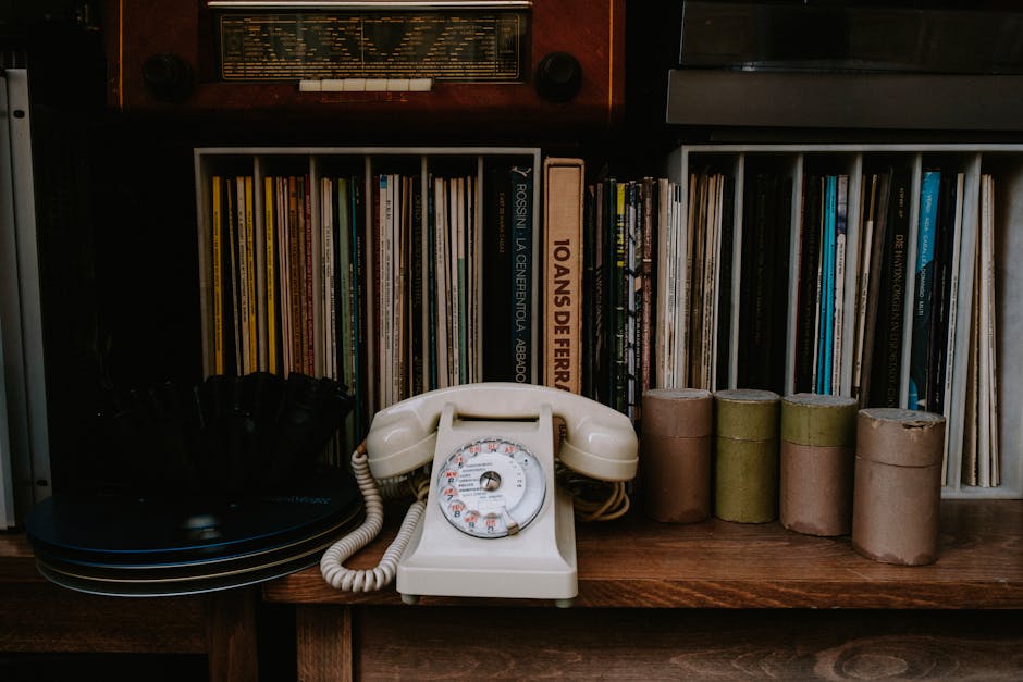 A nostalgic bookshelf featuring a vintage rotary phone and classic literature for a retro vibe.